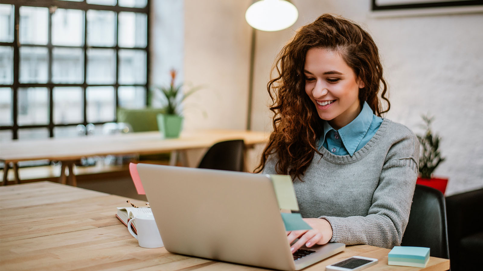 mujer sonriente haciendo sus impuestos en una computadora portátil