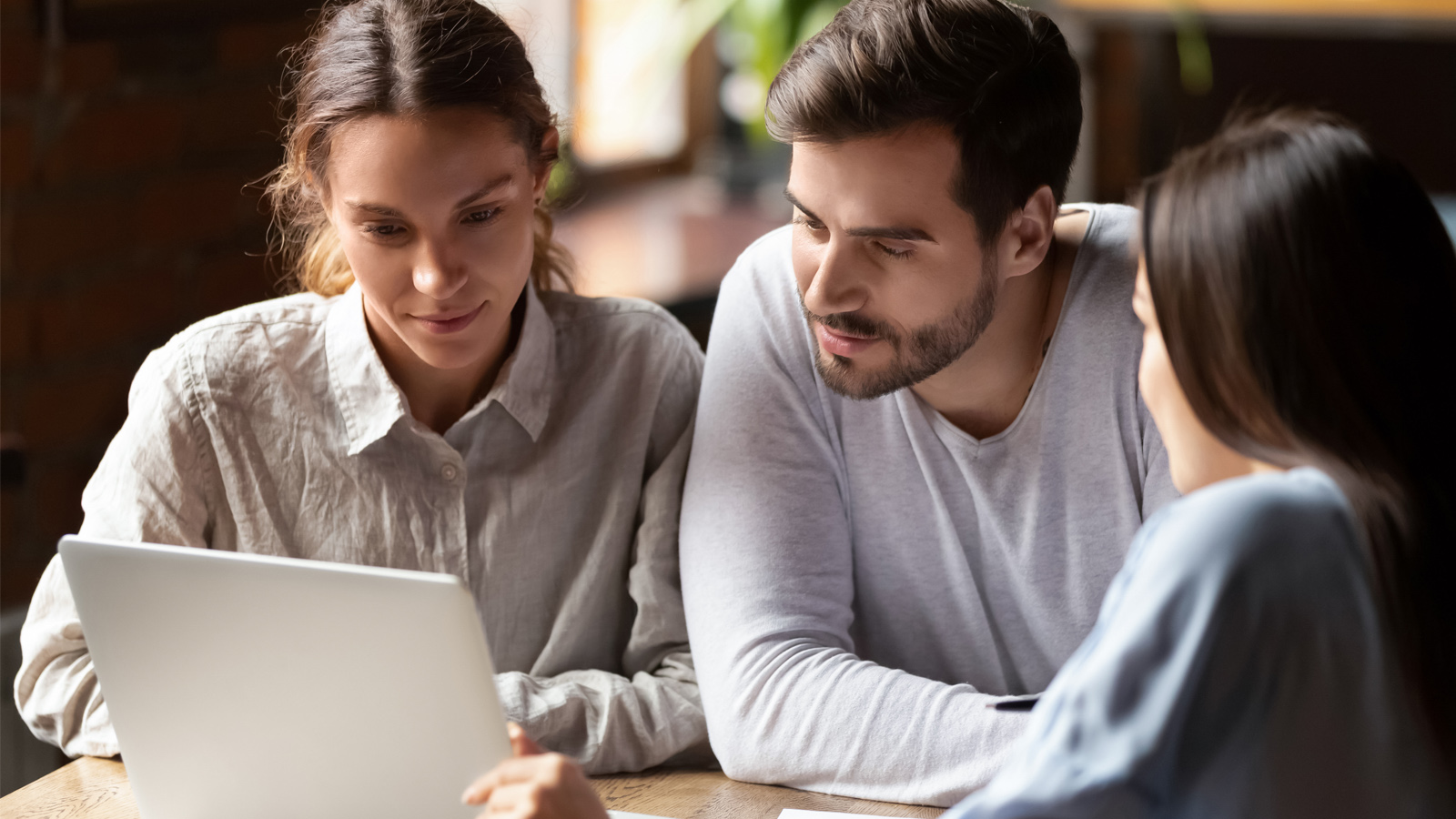 couple showing their laptop screen to their banker