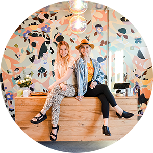 Two women in front of their hair salon