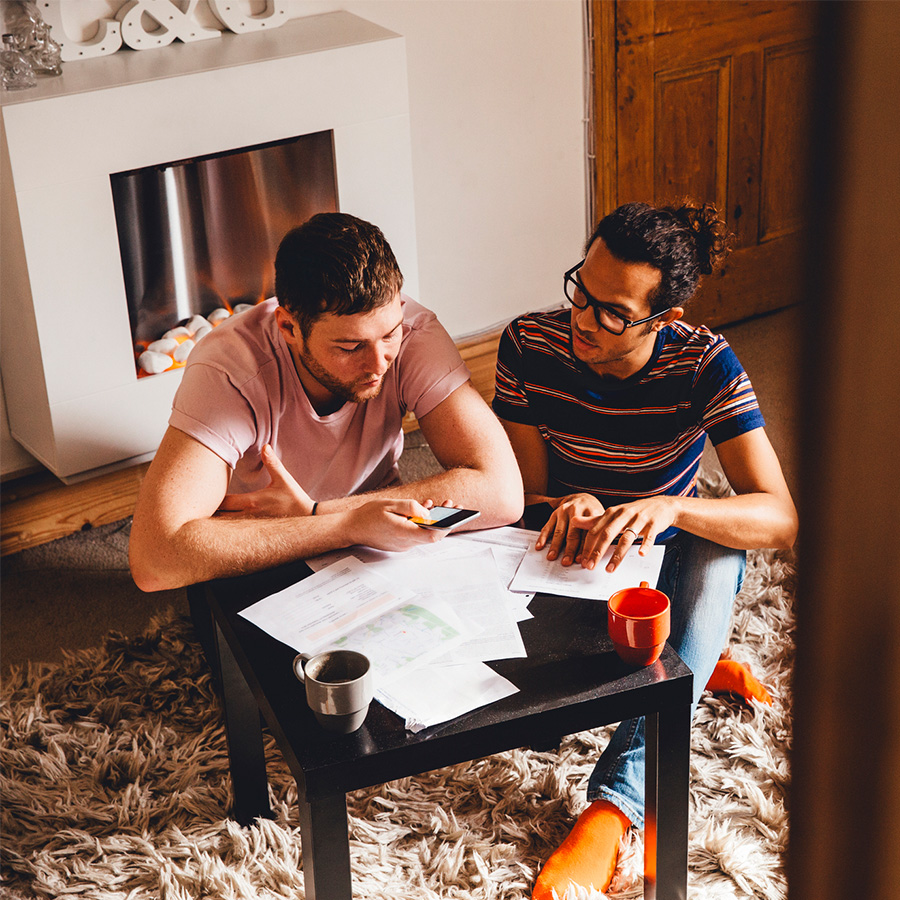 Two men sitting in their living room going over papers