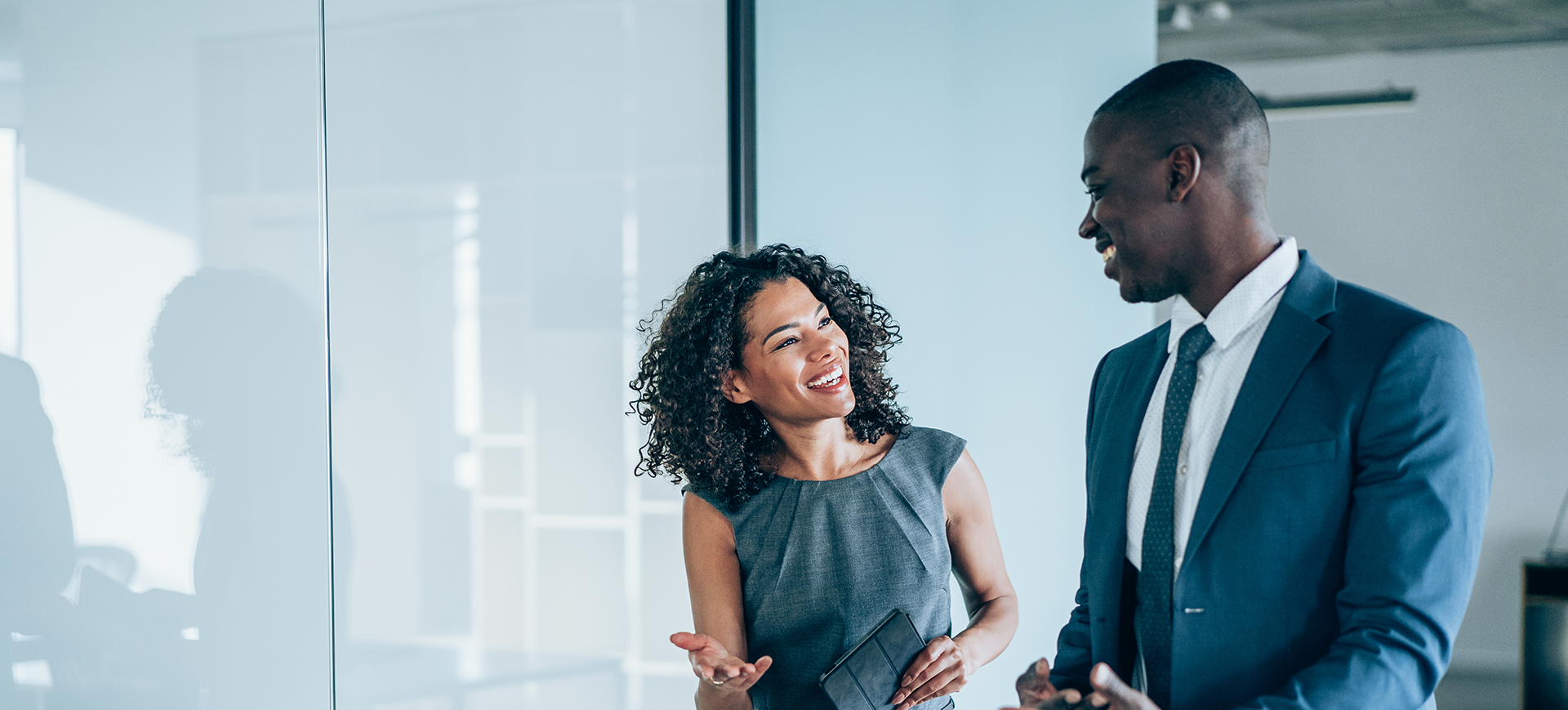 Black man and black woman speaking to each other in an office