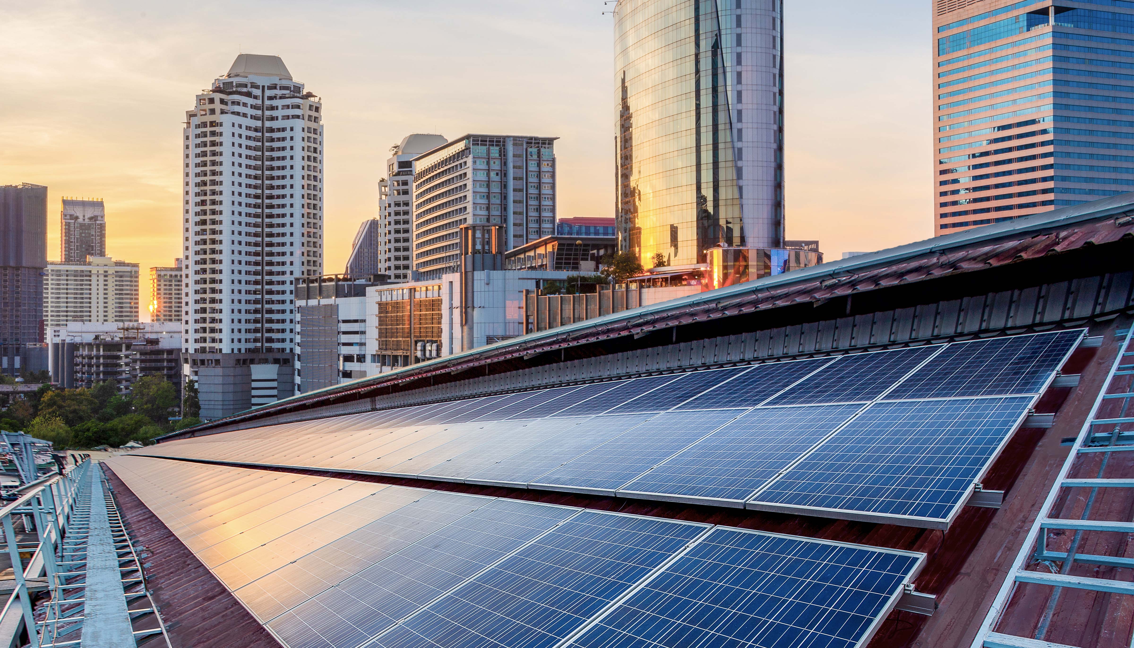 Aerial photo of a large swath of solar panels on top of a building in a downtown area.