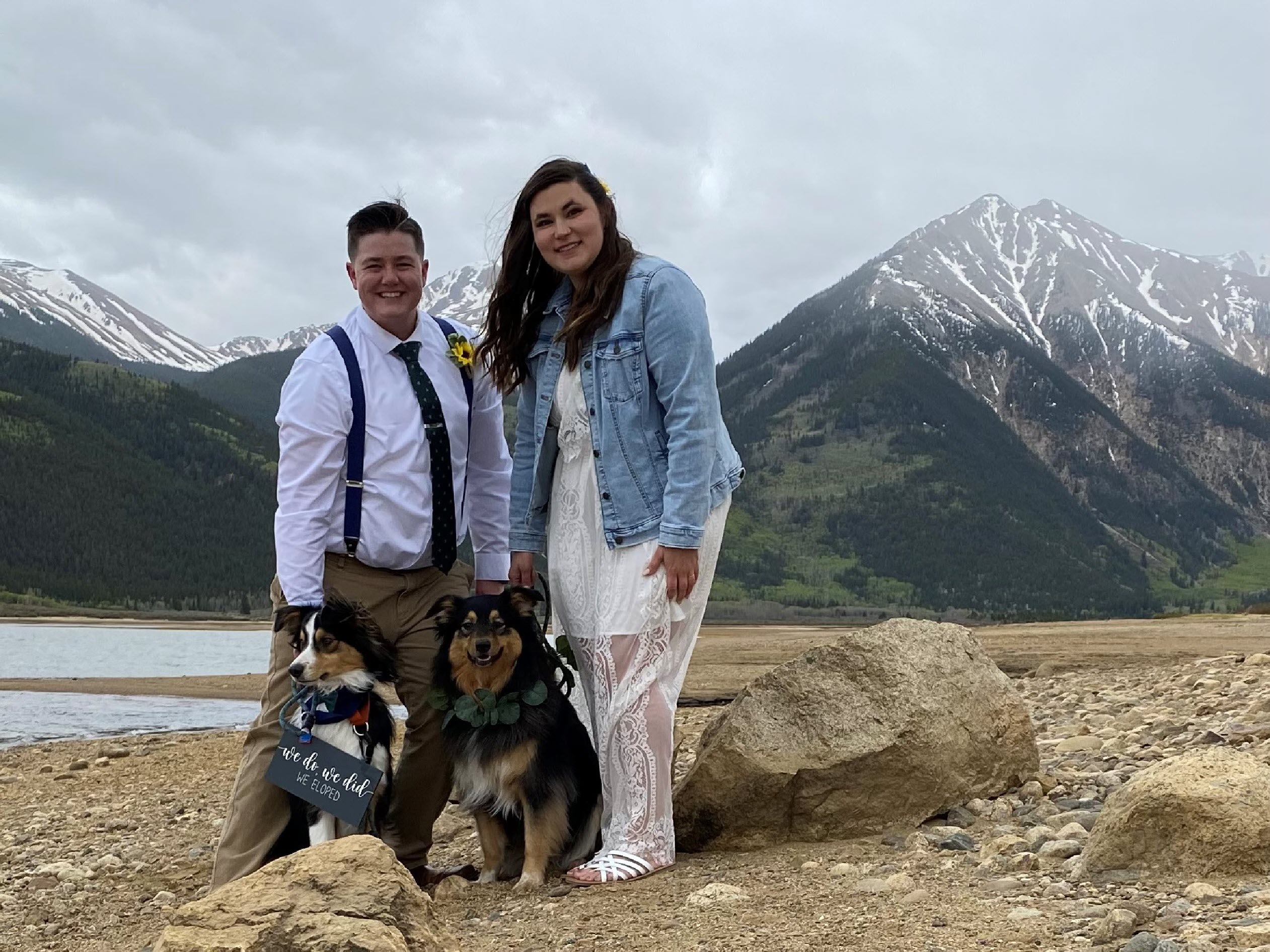 Man, woman and two dogs in front of mountains