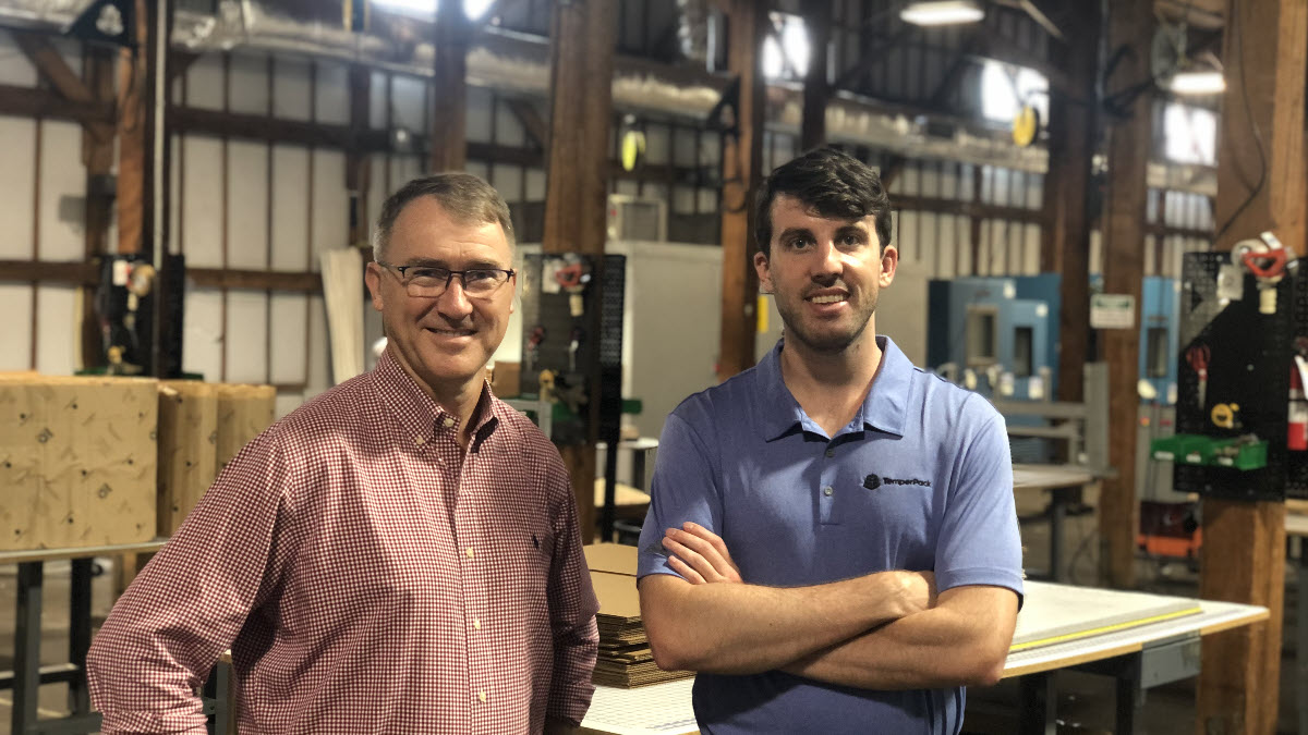 Photo of a middle-aged man and a younger man standing next to each other and smiling at the camera. They are executives of a company called TemperPack.