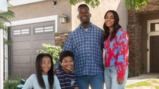 Familia posando fuera de su nueva casa.