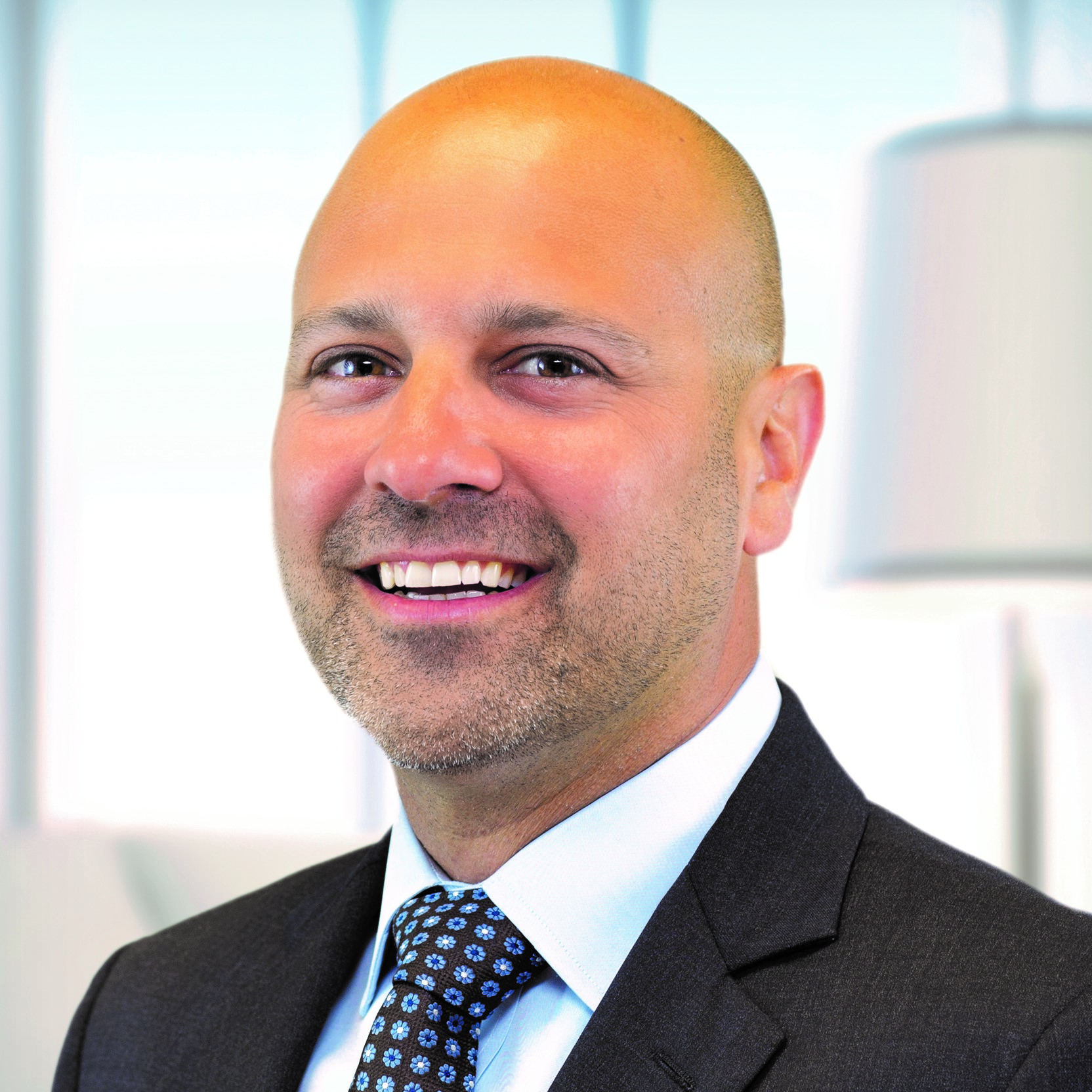 Headshot of Brian Bekiers wearing a suit and tie