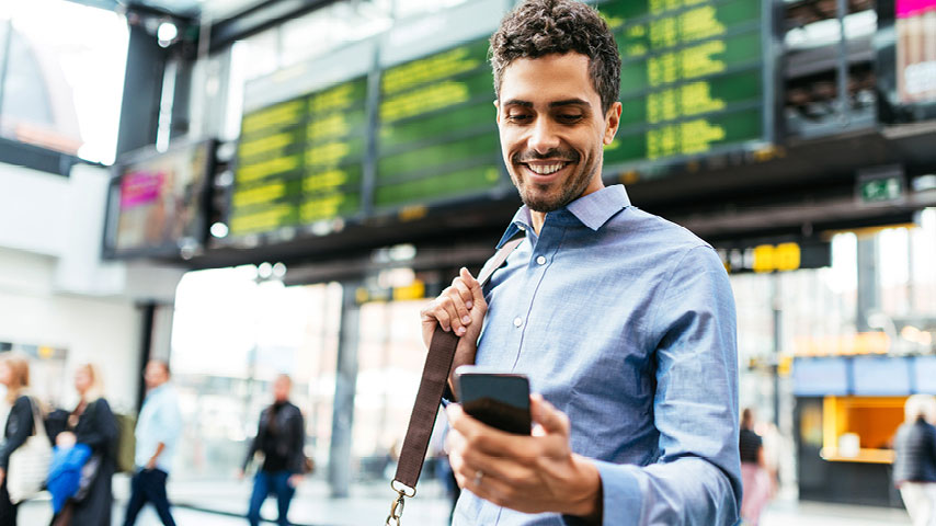 Man looking at his smartphone while traveling.