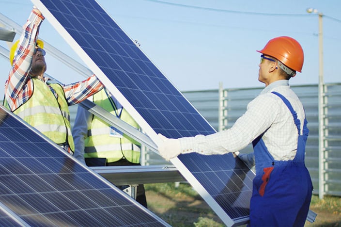 Two electrical workers installing solar panels