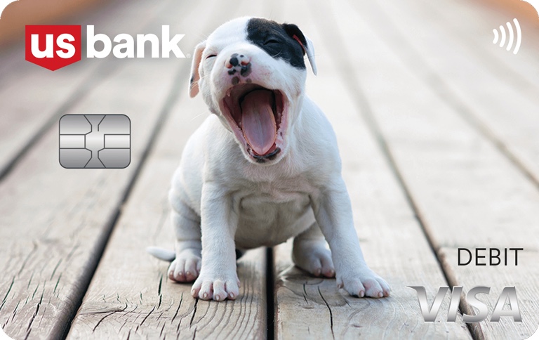 Puppy - Yawning white puppy with black around eye and ear sitting on wood deck