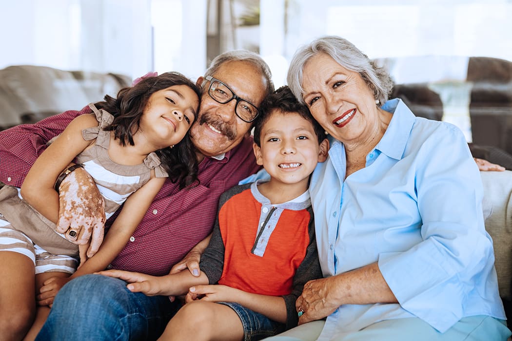 Family sitting on couch smiling