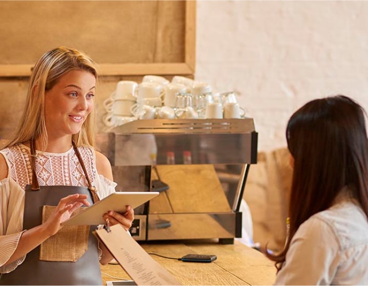 Server taking an order from a customer at a restaurant.