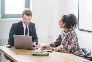 man and woman in meeting with laptop