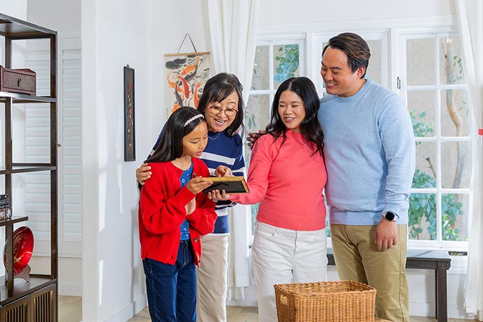 Multigenerational family looking at a framed photo.