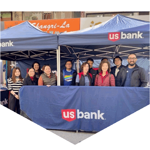 Large group of U.S. Bank employees smiling for a photo at their event booth.