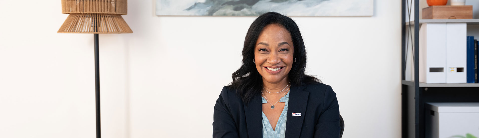 U.S. Bank employee sitting at a desk smiling.