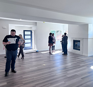 Group of people inside an unfurnished home.