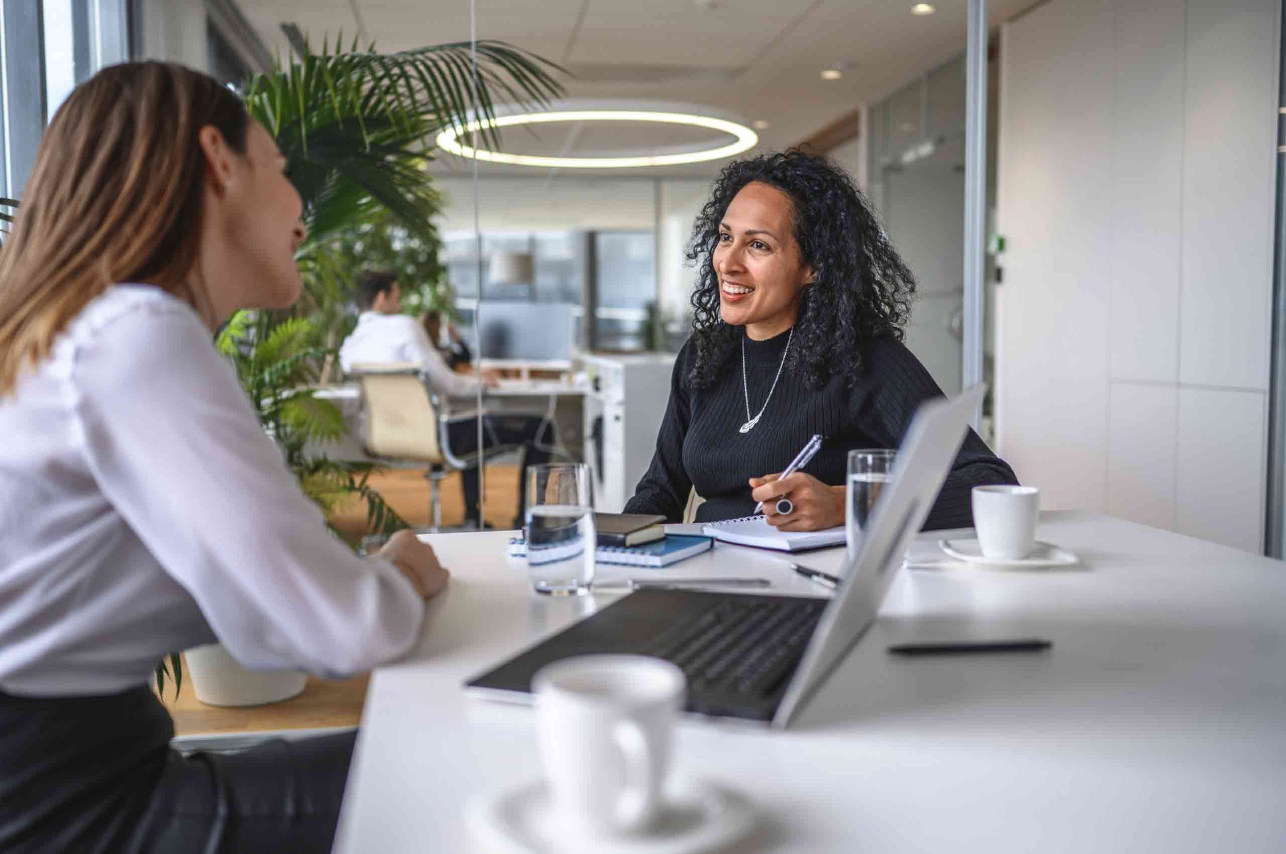 A reporter interviews and employee at a conference table