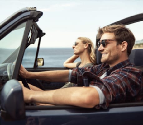 Man and woman driving in convertible