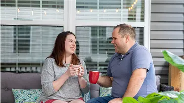A couple sitting on their home patio talking
