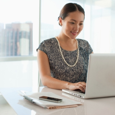 Person sitting at desk working at a laptop.