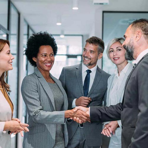 Group of corporate colleagues greeting each other in an office