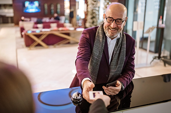 Person holding mobile device to a point of sale reader using virtual payments