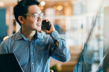 A person smiling and talking on their mobile phone 