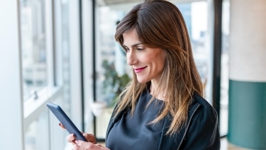 Person holding a tablet in both hands while looking at it. 