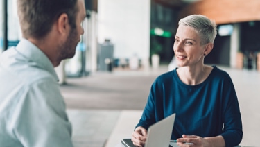 Two people sitting and talking at a table