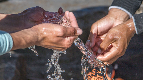 Water running over two pair of hands