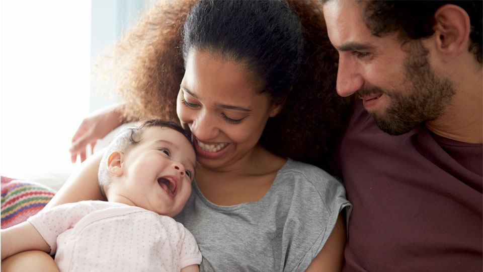 parents cuddling baby