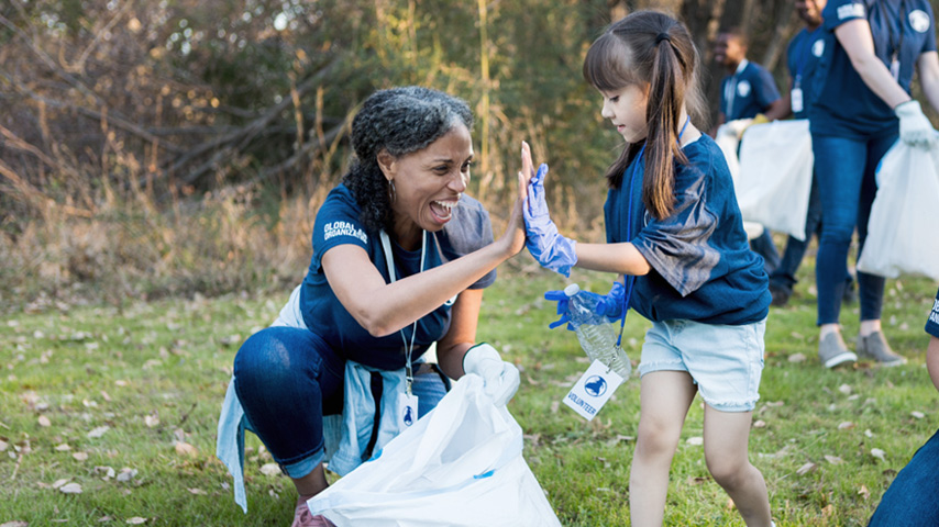 Woman and young girl collecting trash