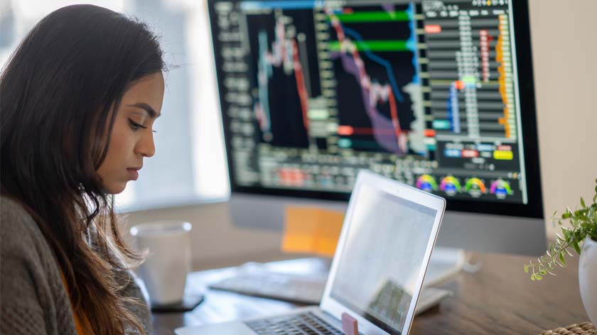 Woman at desk with stock market data