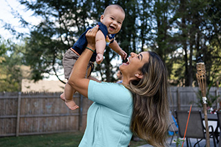 Woman holding up her young child