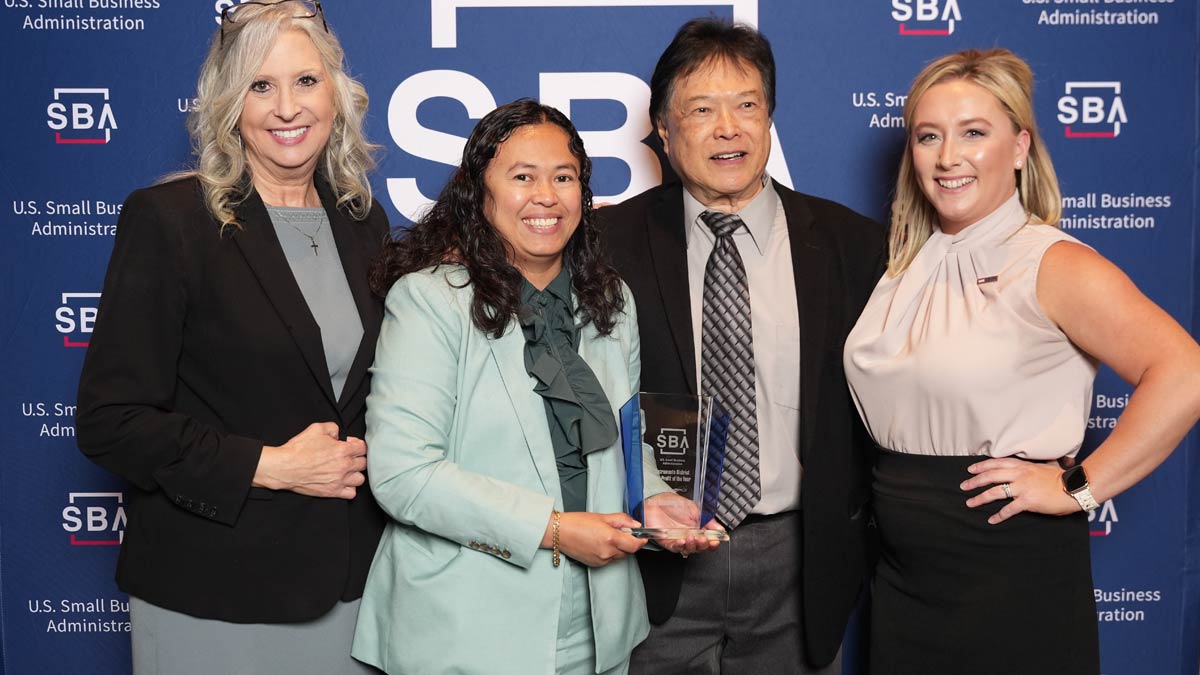 Four people holding an award