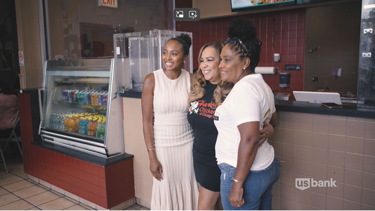 Three women posing together at a restaurant near the front counter