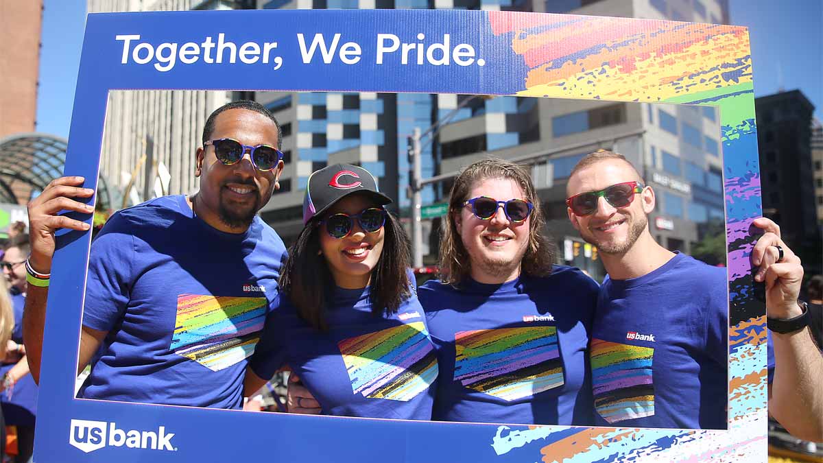 People wearing U.S. Bank shirts holding a sign at a parade