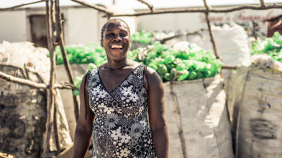 Woman standing in front of a collection of plastic bottles.