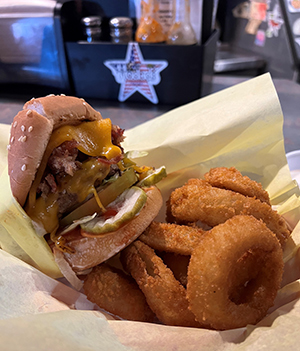 A bacon cheeseburger with onion rings.