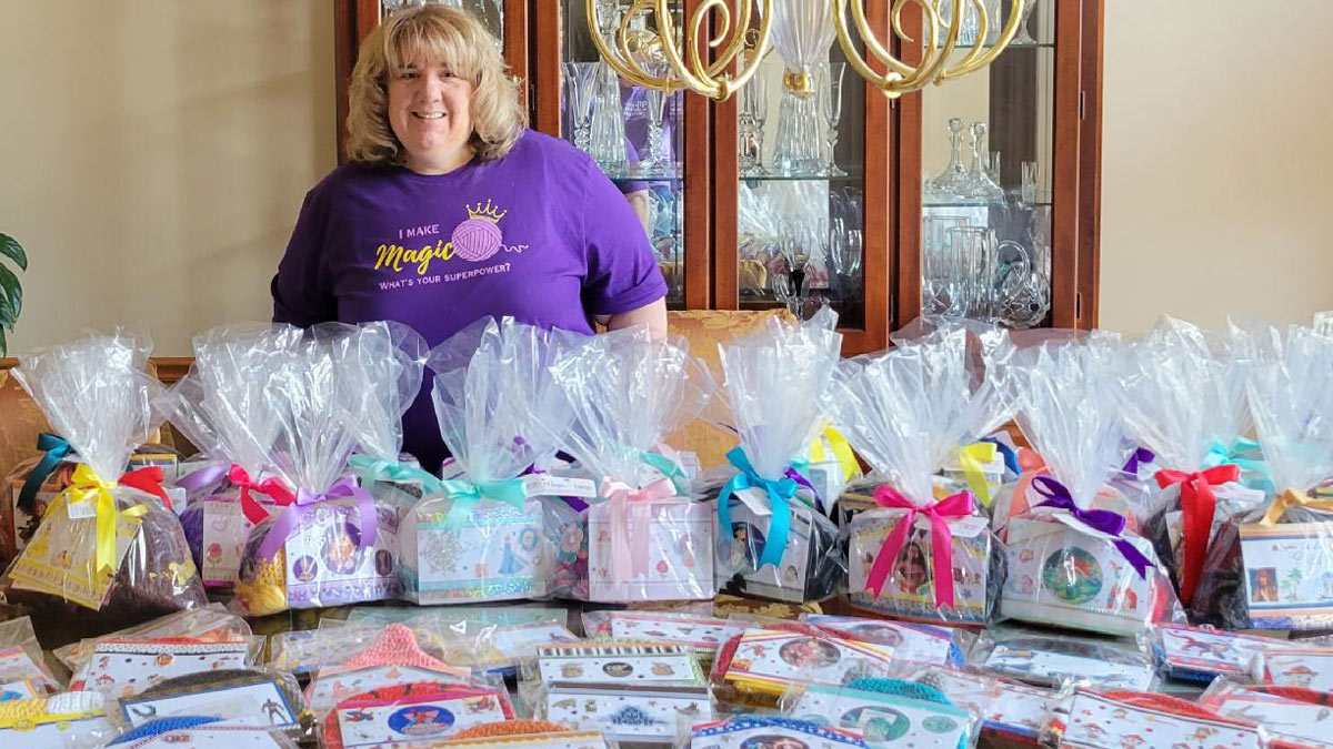 Woman standing behind table that has wrapped packages on it.