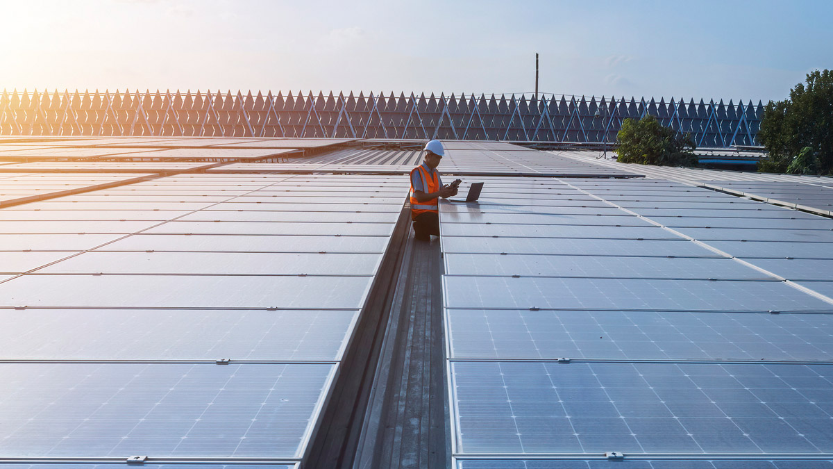 Man on roof with solar panels.