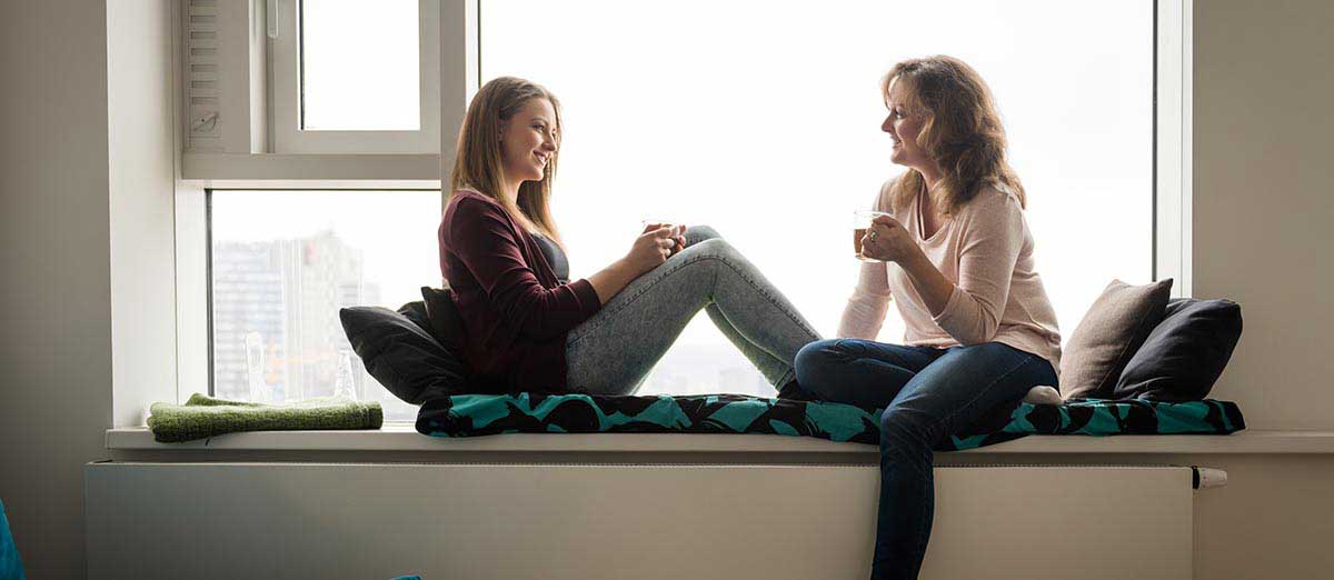 Mujeres sonriendo y hablando entre ellas.