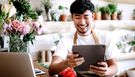 Shop owner looks at tablet device