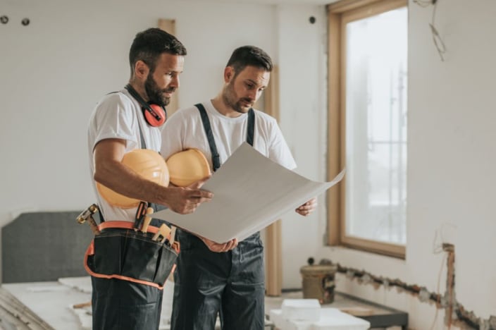 Photo of contracters looking at building plans