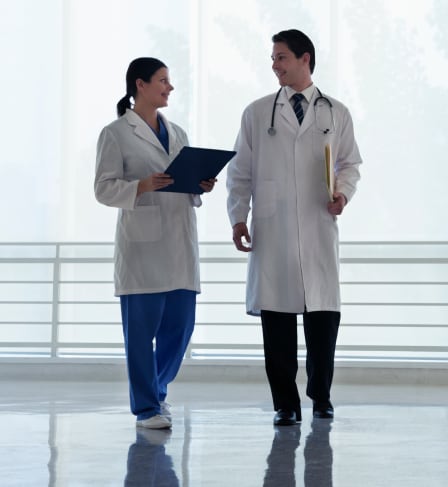 Two doctors walking together down a hallway