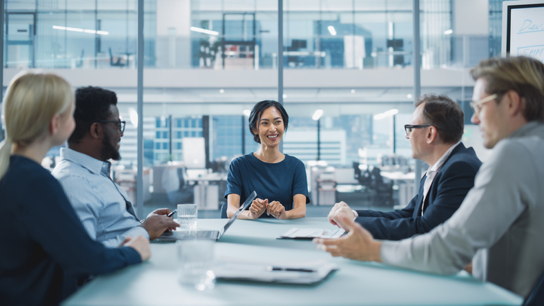 Five people in a modern conference room having a meeting. 