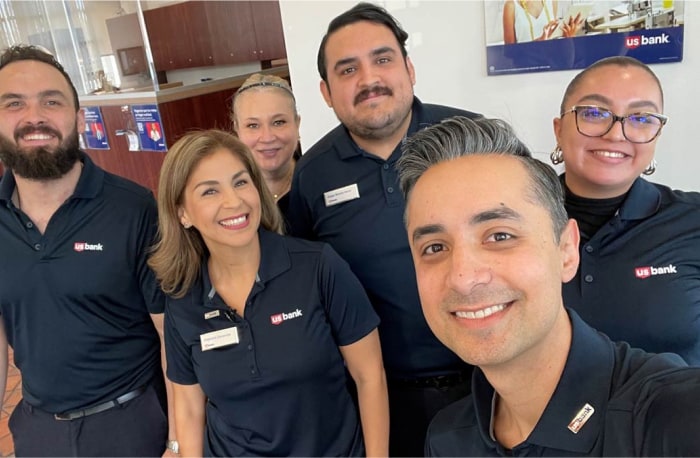 El gerente de sucursal Andrés Malfavon y su equipo sonríen para una selfi en San Ysidro, California.