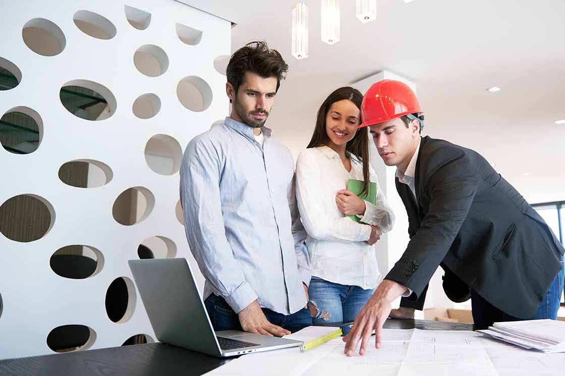 couple looking at blueprints with architect