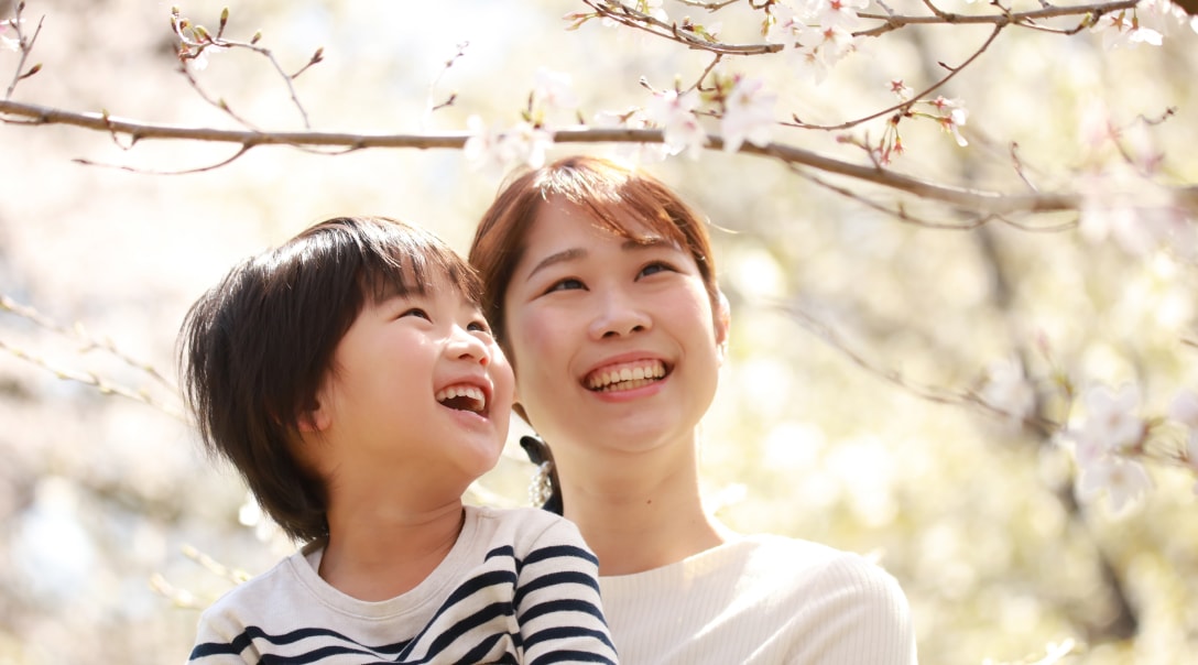 Una madre japonesa con su hijo disfrutando los cerezos que se arquean sobre sus cabezas.