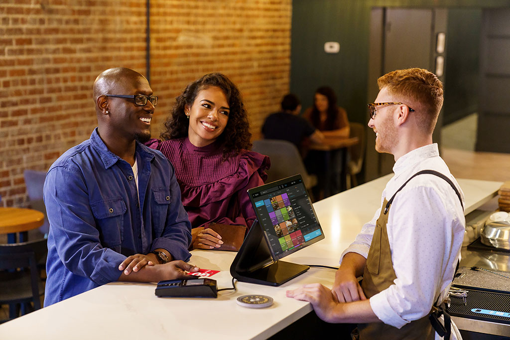 Man and woman at register with credit card